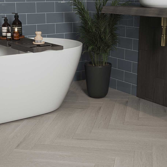 Bathroom with a white freestanding bathtub, dark tiled wall, and wooden floor. 6